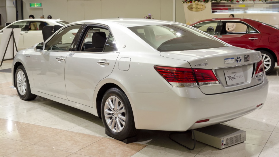 Rear and side view of a white luxury sedan with distinct taillights and alloy wheels