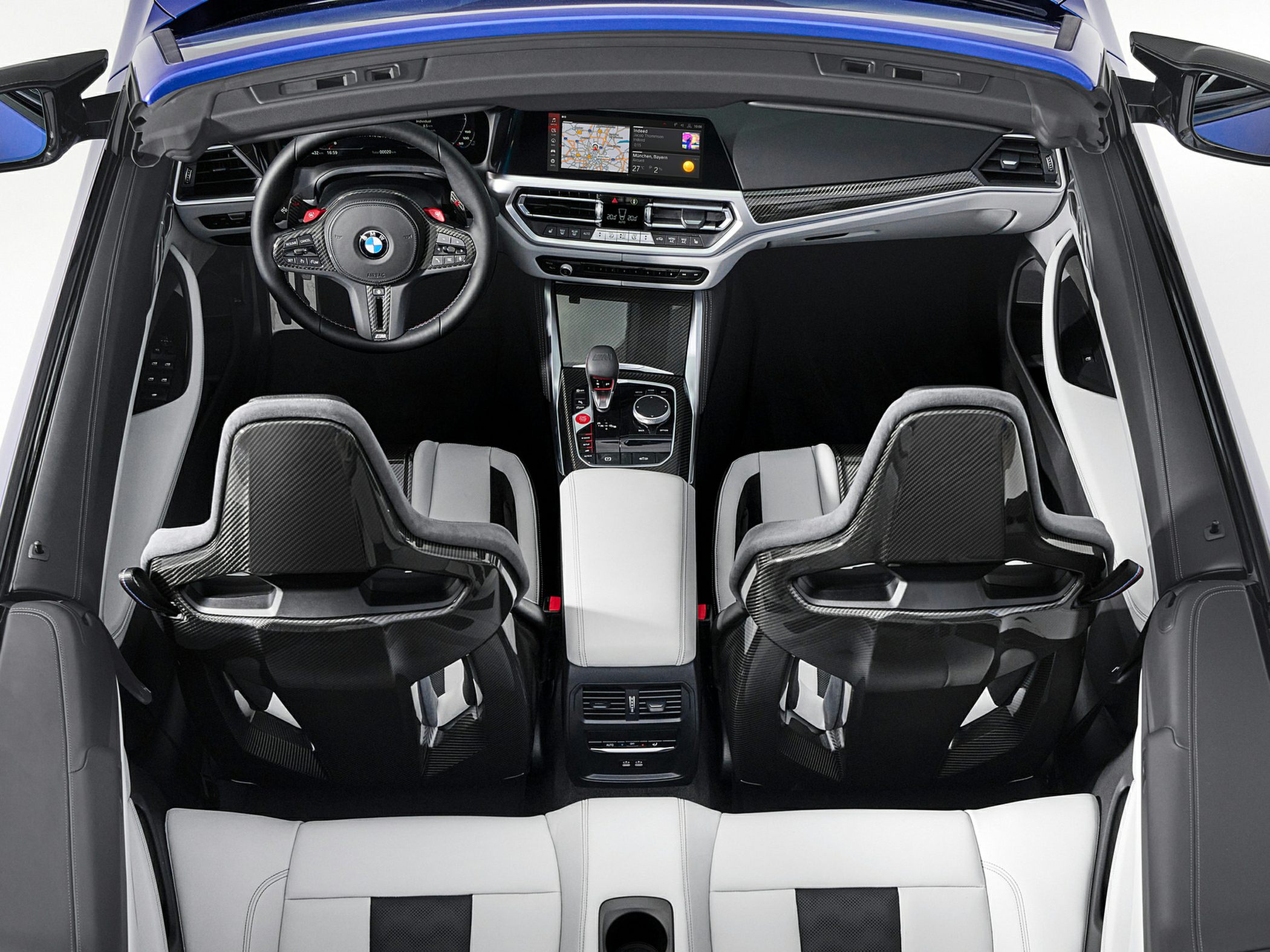 Interior view with carbon fiber racing seats and modern dashboard.