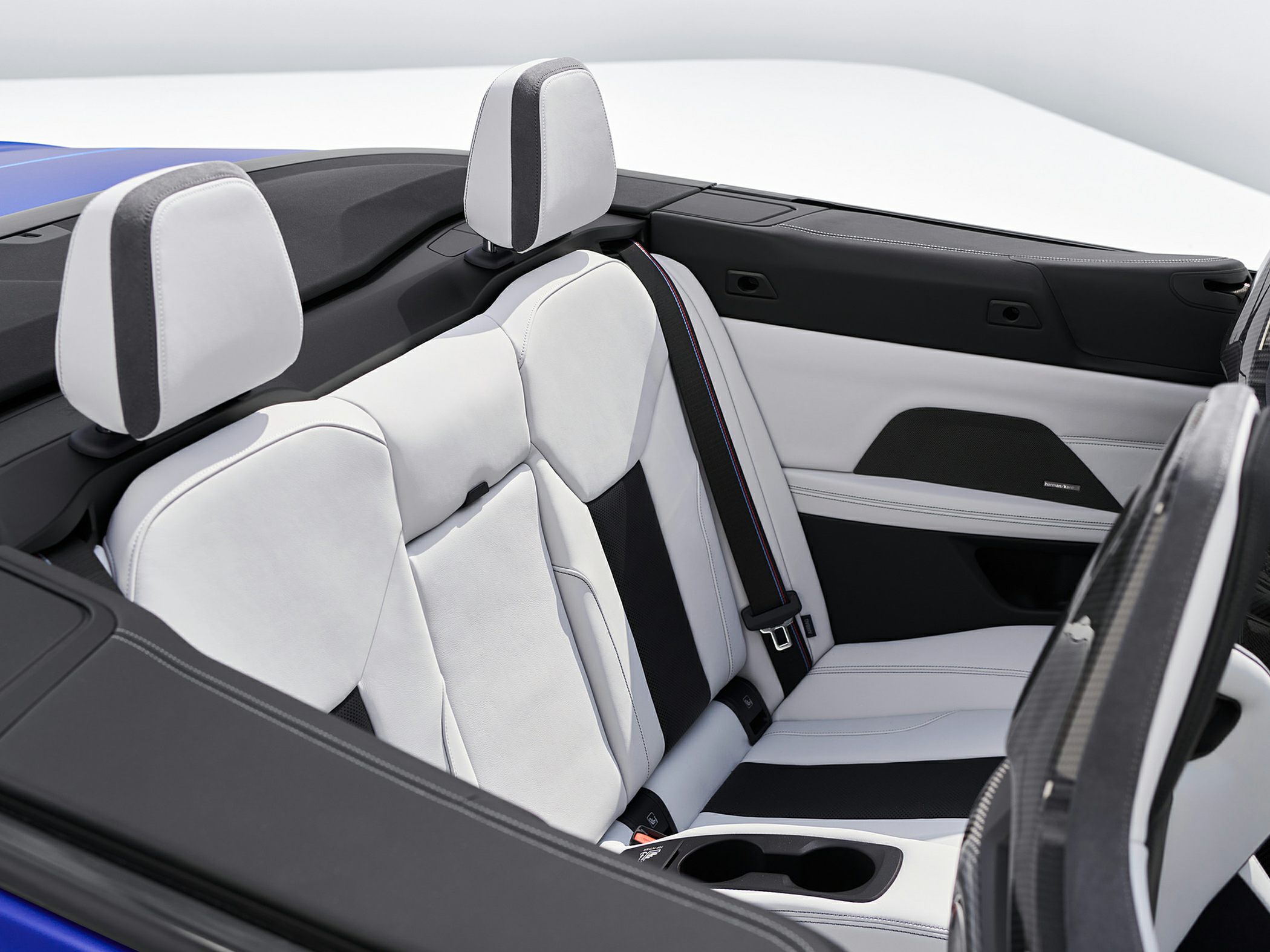White and black rear convertible seats with headrests and cup holders