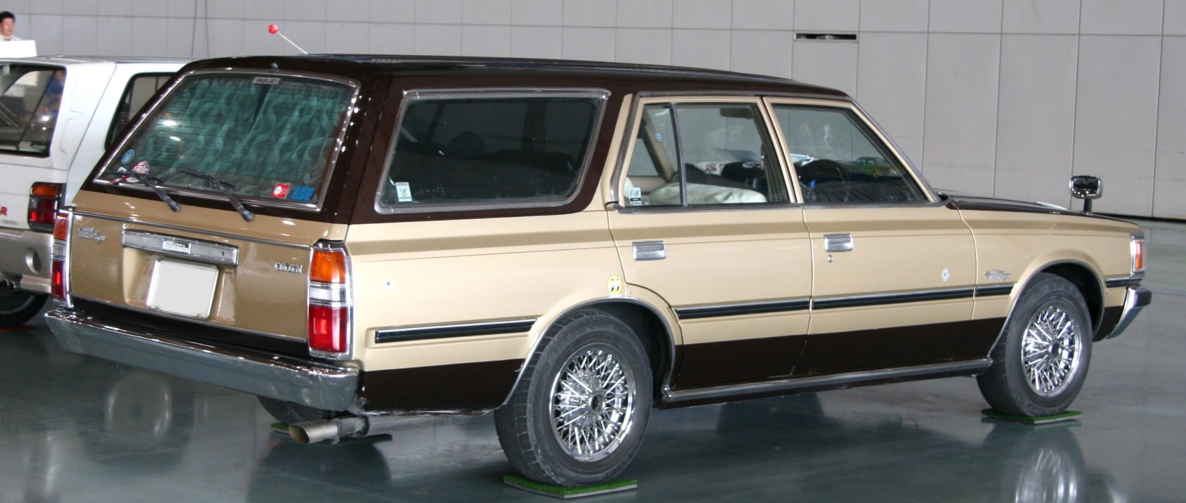 Two-tone beige-brown station wagon with wire-spoke wheels and rear wiper