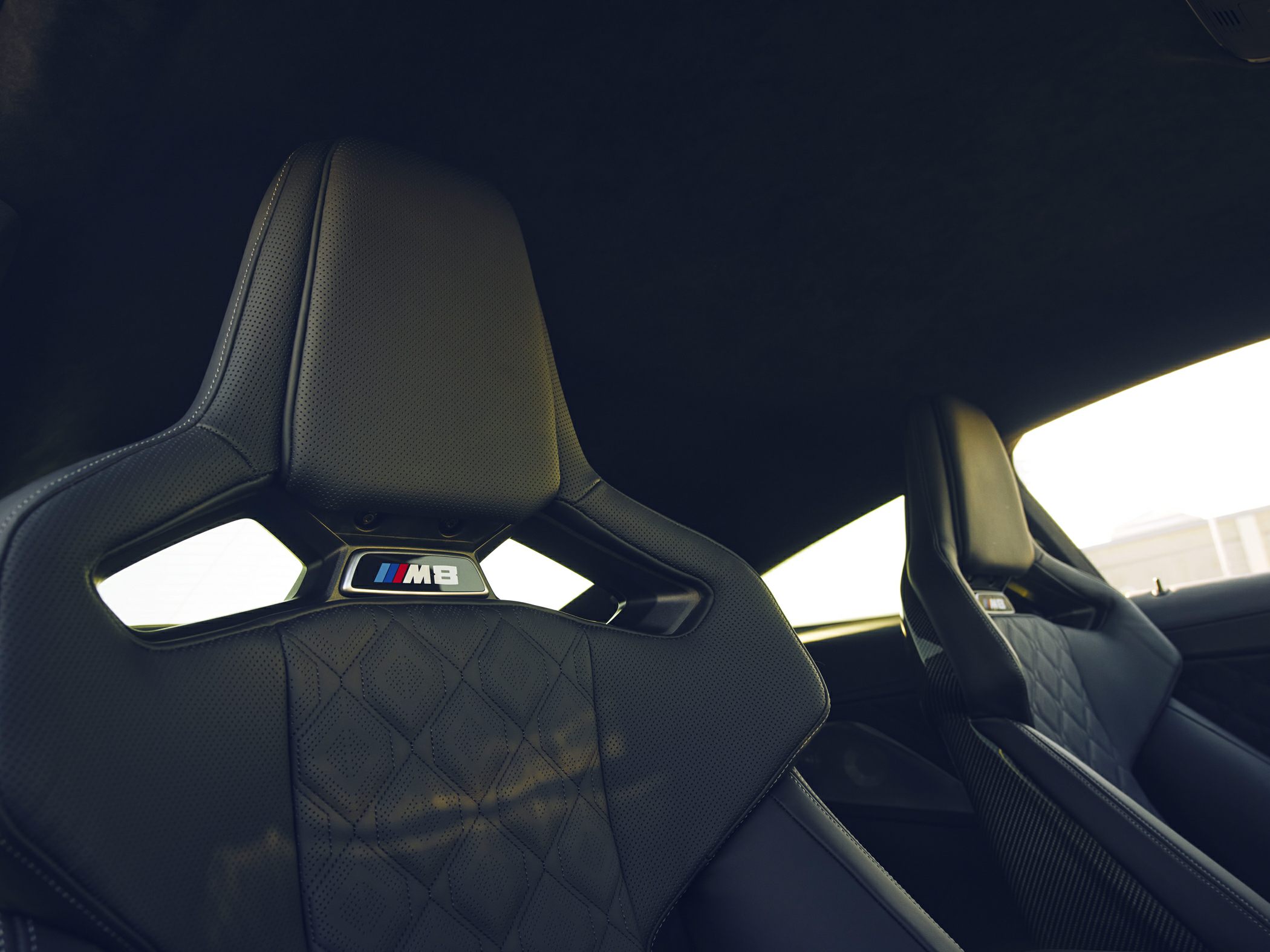 Sporty perforated leather seats with diamond stitching and carbon fiber backs