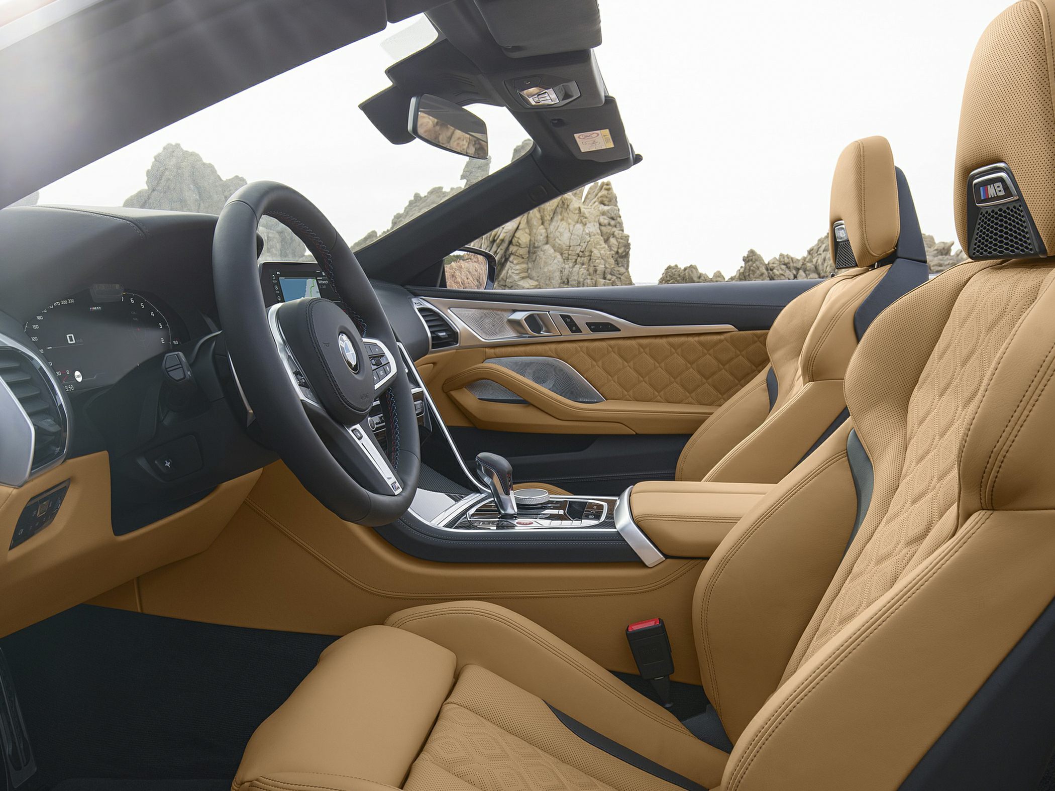 Luxurious tan leather sport seats with modern dashboard and steering wheel.