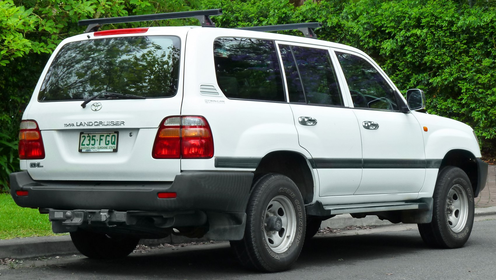 Rear view of white SUV with large tail lights and roof rack