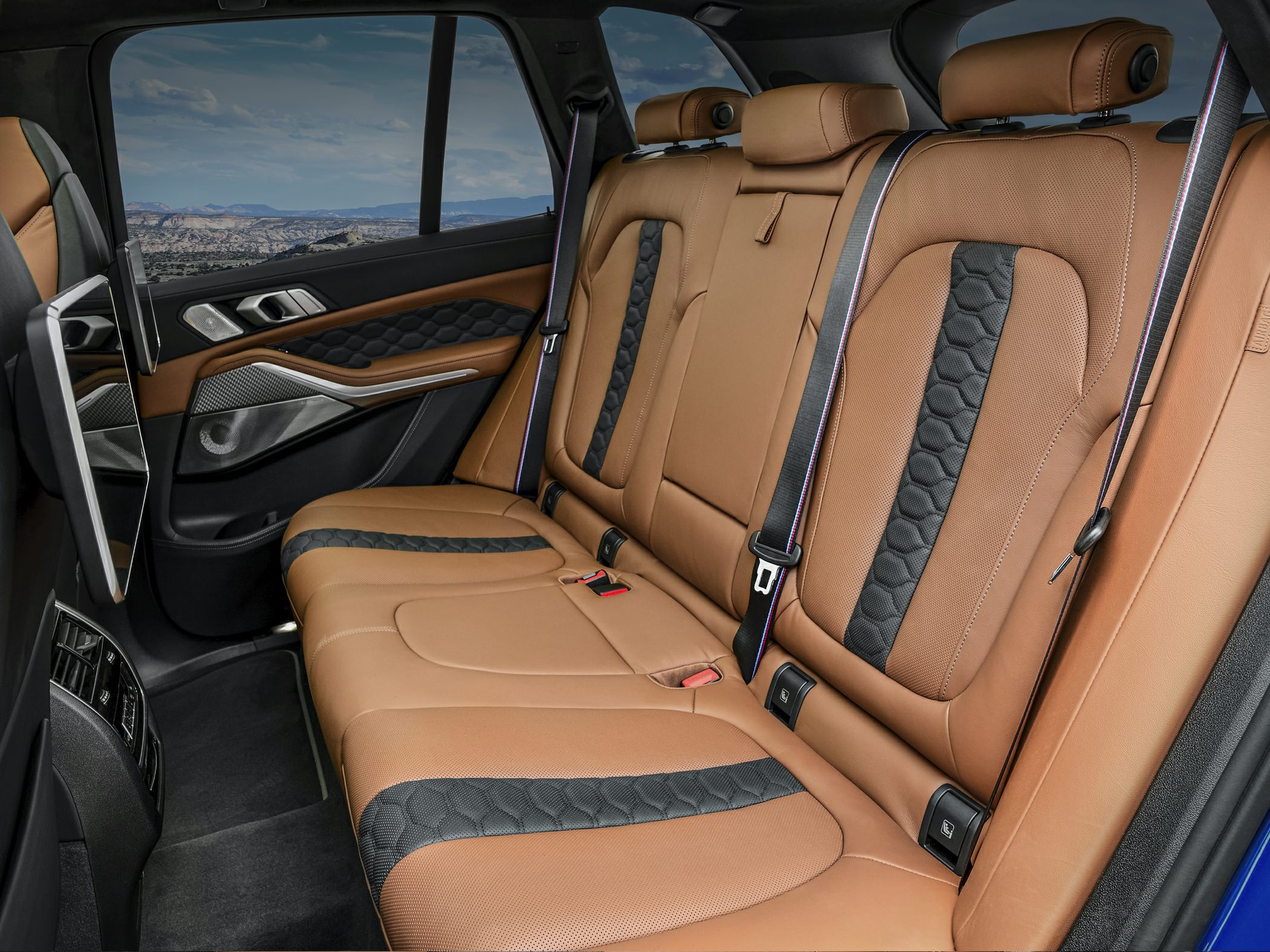 Brown and black leather rear seats with quilted patterns and detailed stitching.