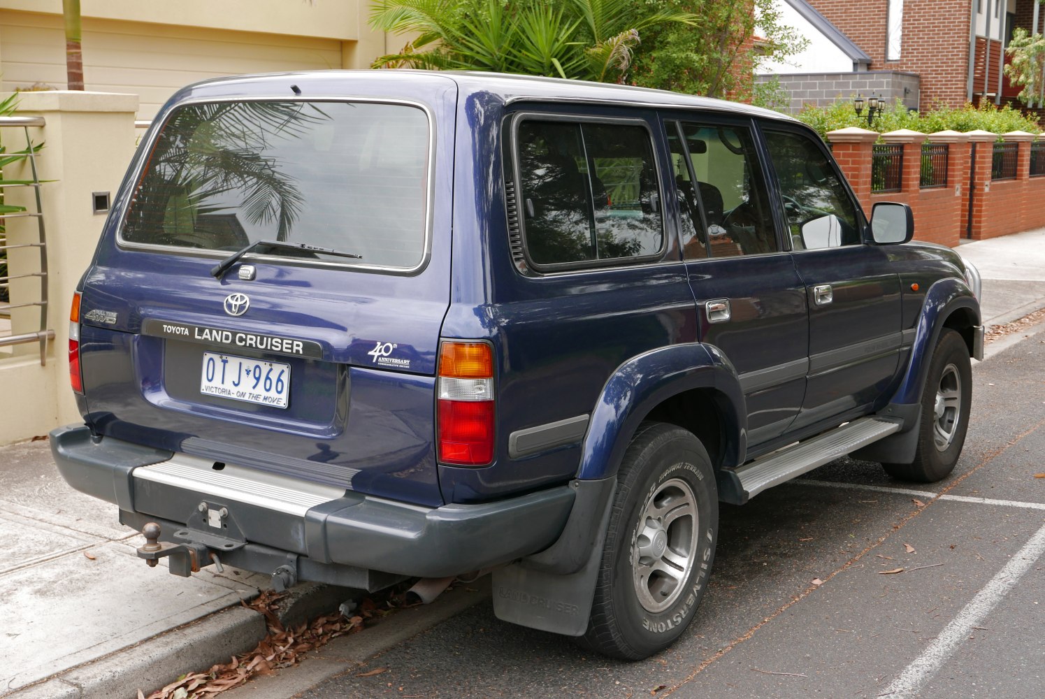 Rear and side view of a large SUV with tow hitch and tinted windows