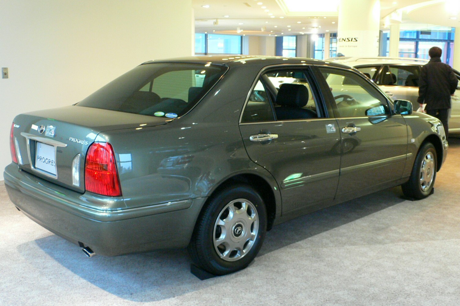 Rear side view of a classic late-90s sedan with alloy wheels and distinctive tail lights