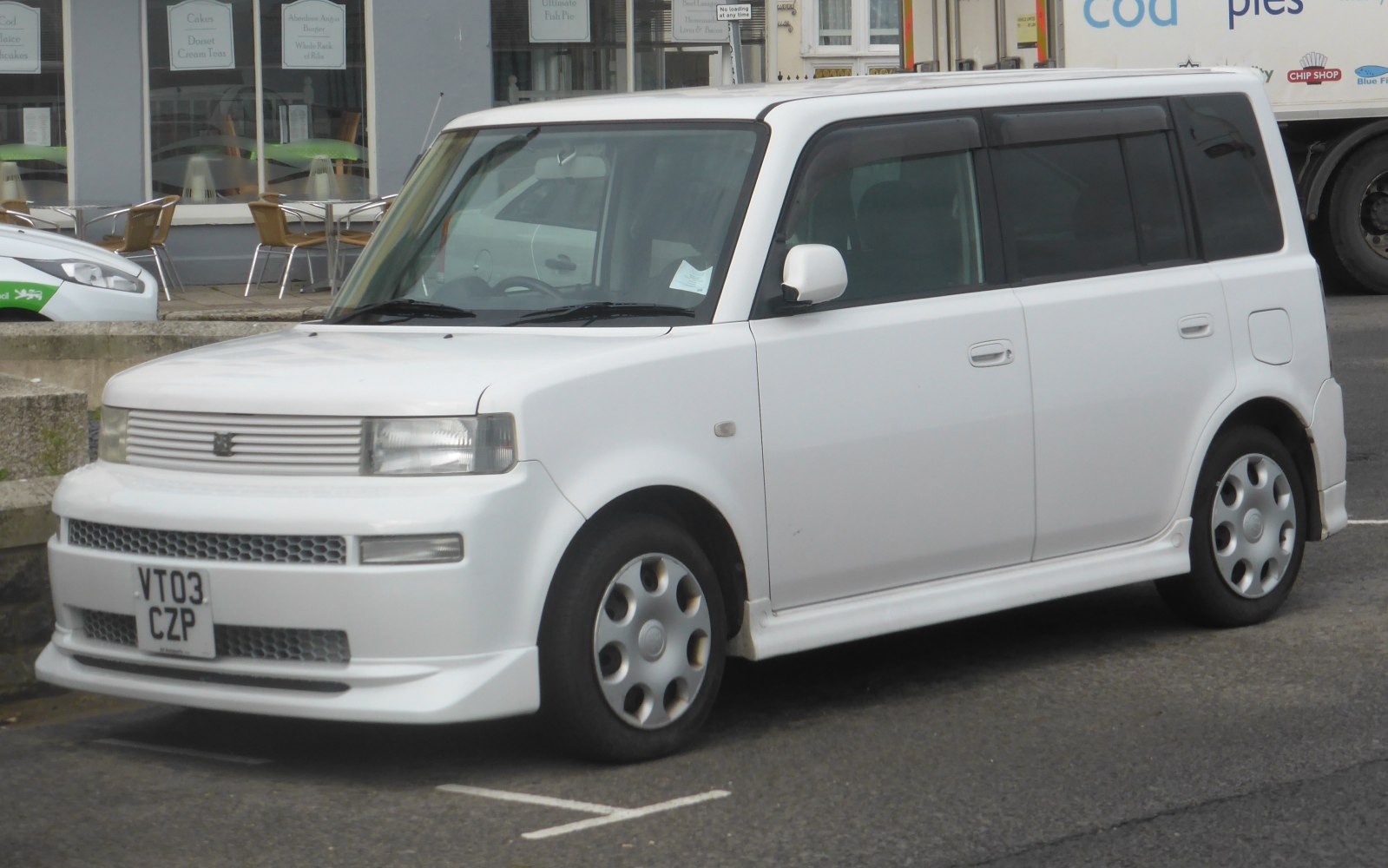 Boxy compact hatchback with flat front grille and rounded headlights