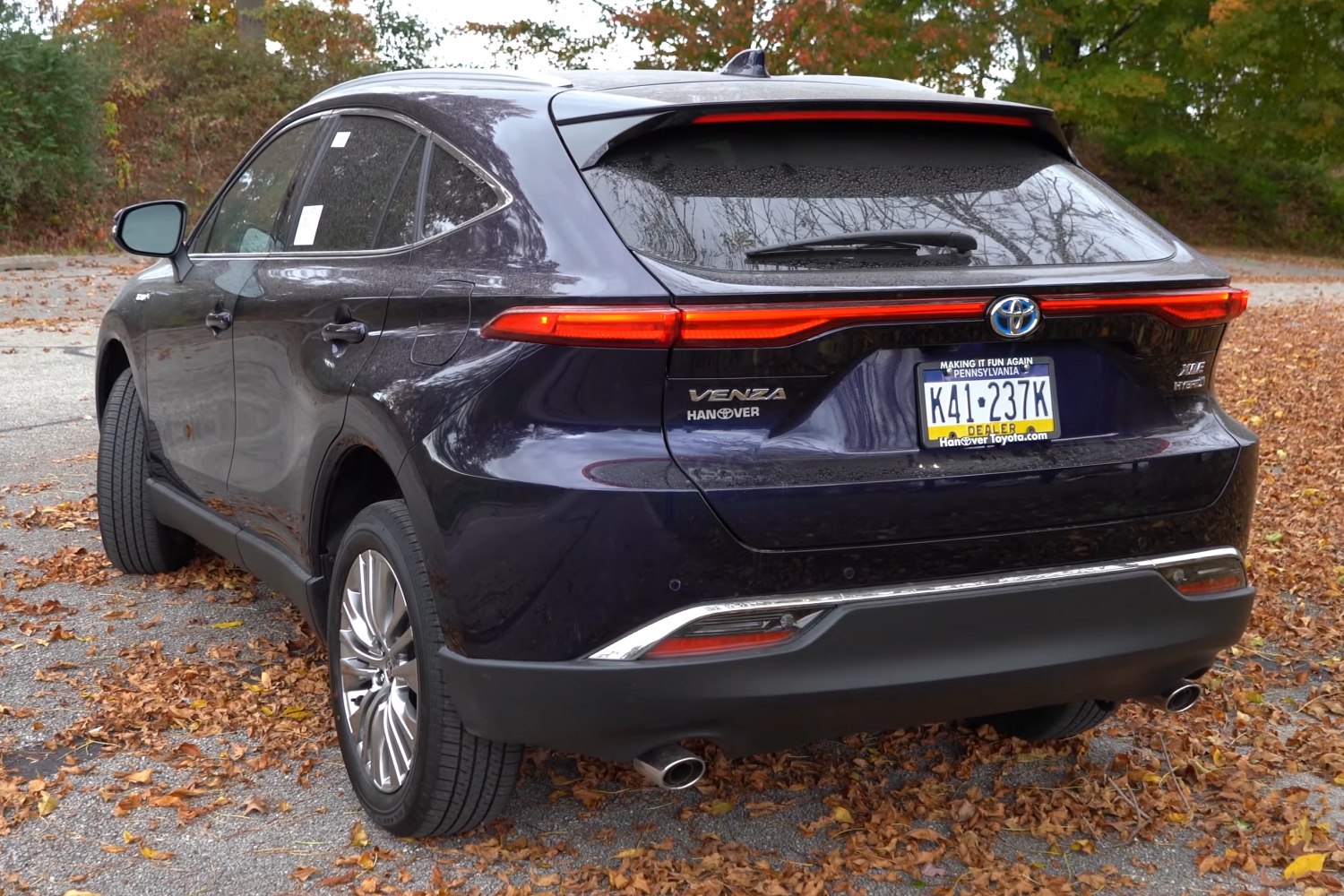 Sleek continuous LED tail lights and dual exhaust of a modern SUV rear.