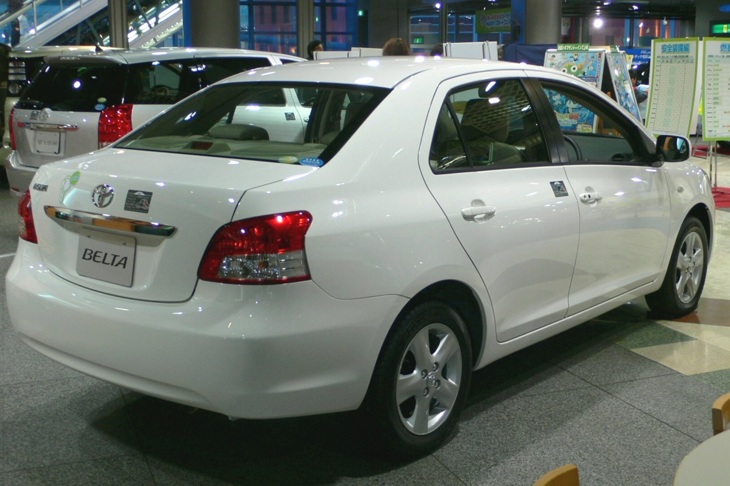 Rear and side view of a white sedan with modern taillights and smooth body design
