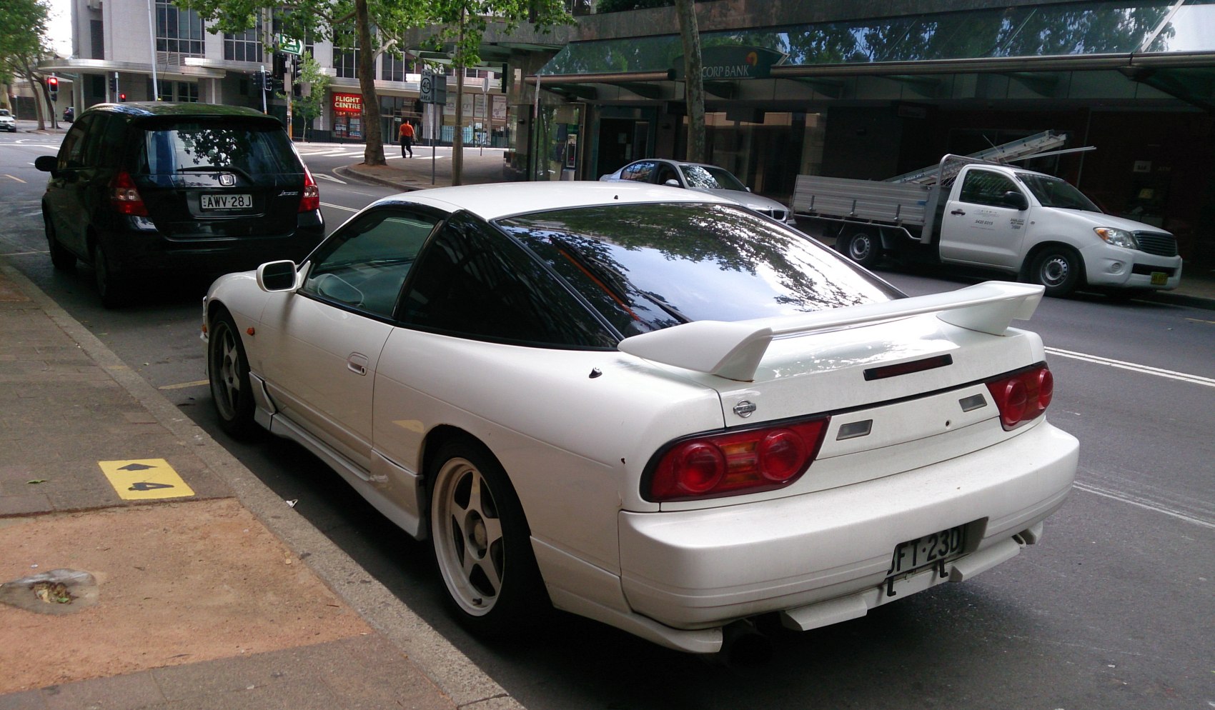 White coupe rear view, rear spoiler, distinctive taillights