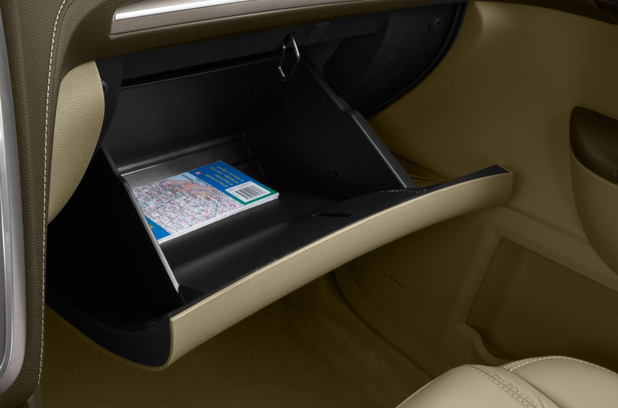 Open glove compartment with a map inside and beige interior.