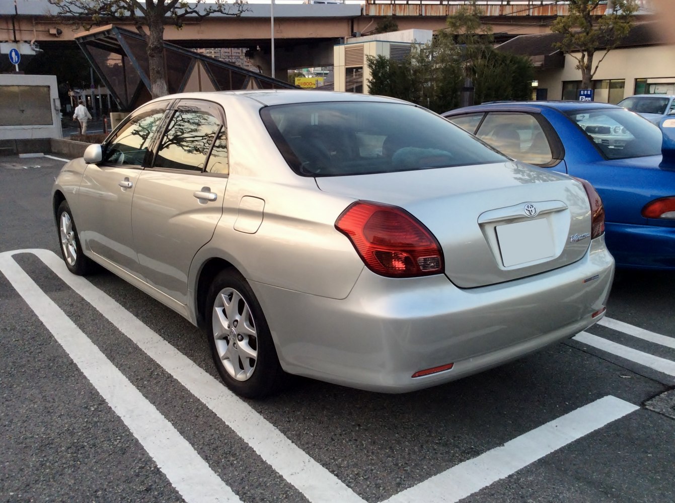 Silver sedan rear side with large taillights and alloy wheels