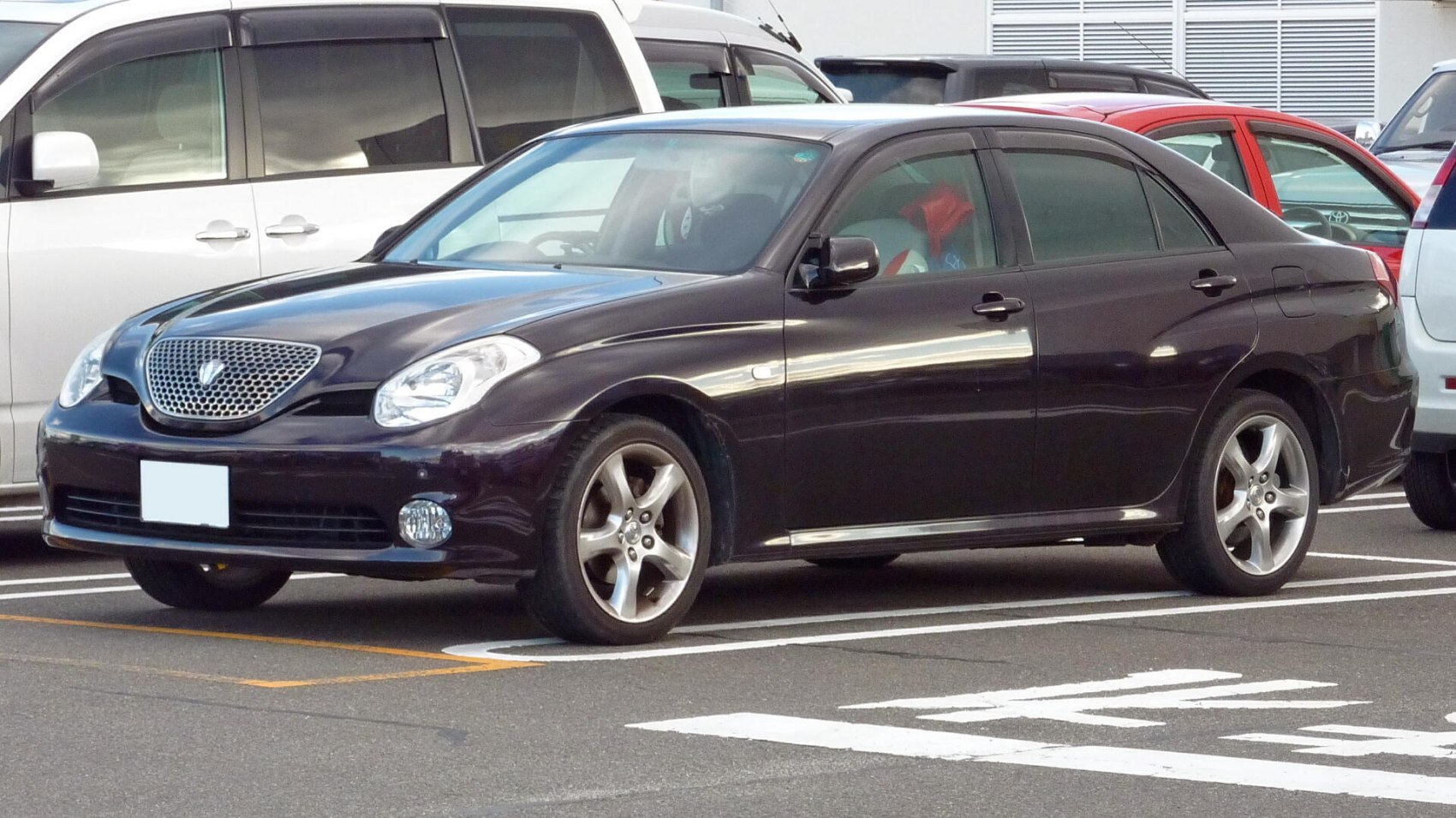 Luxury sedan with mesh grille and alloy wheels, front-side perspective