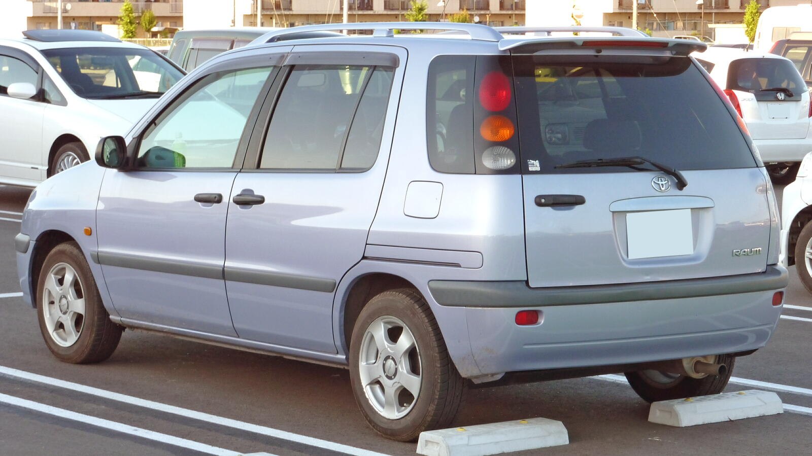 Rear side view of a compact MPV with distinct taillights and rear door