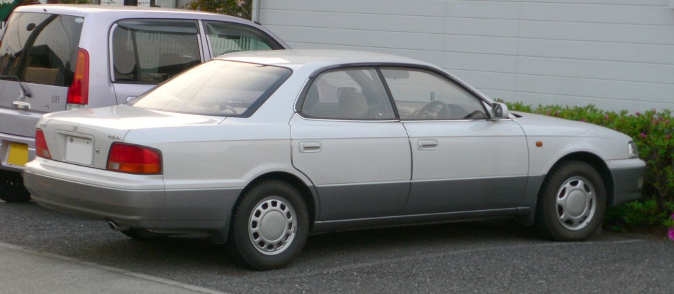 Side and rear profile of a two-tone sedan with classic early 90s design