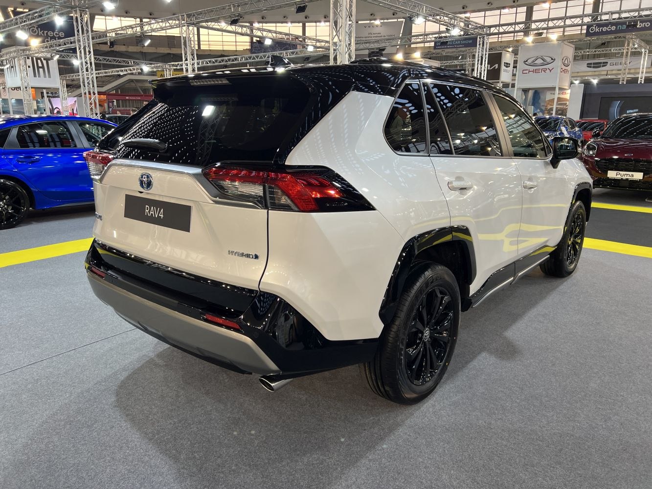 Rear view of a hybrid SUV with black roof and sporty tail lights