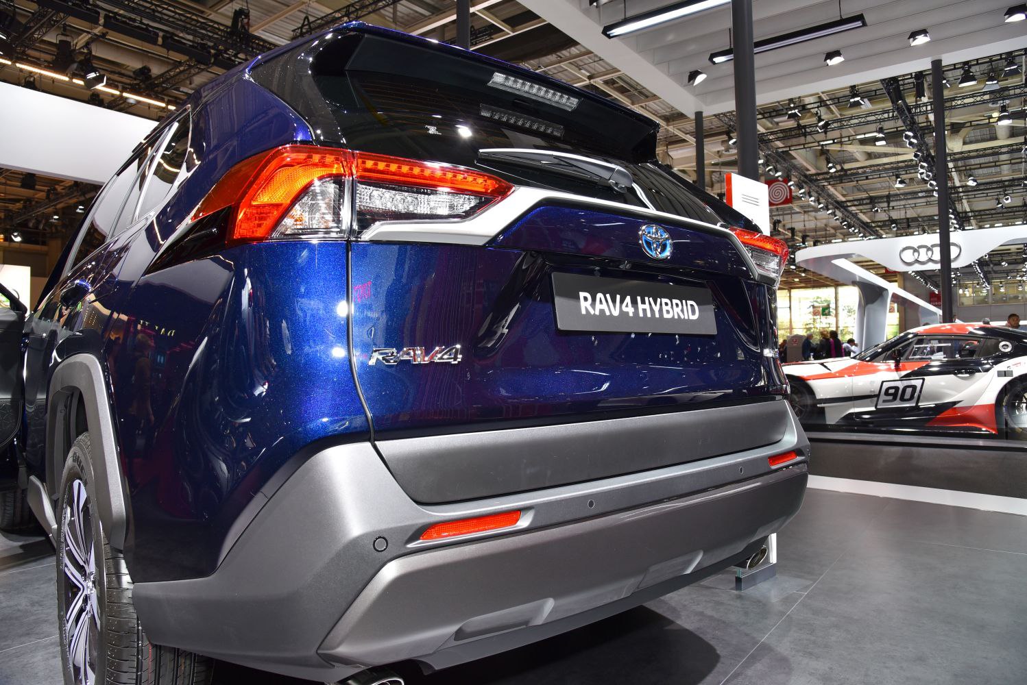 Rear view of an SUV featuring hybrid badge, taillight, and bumper design