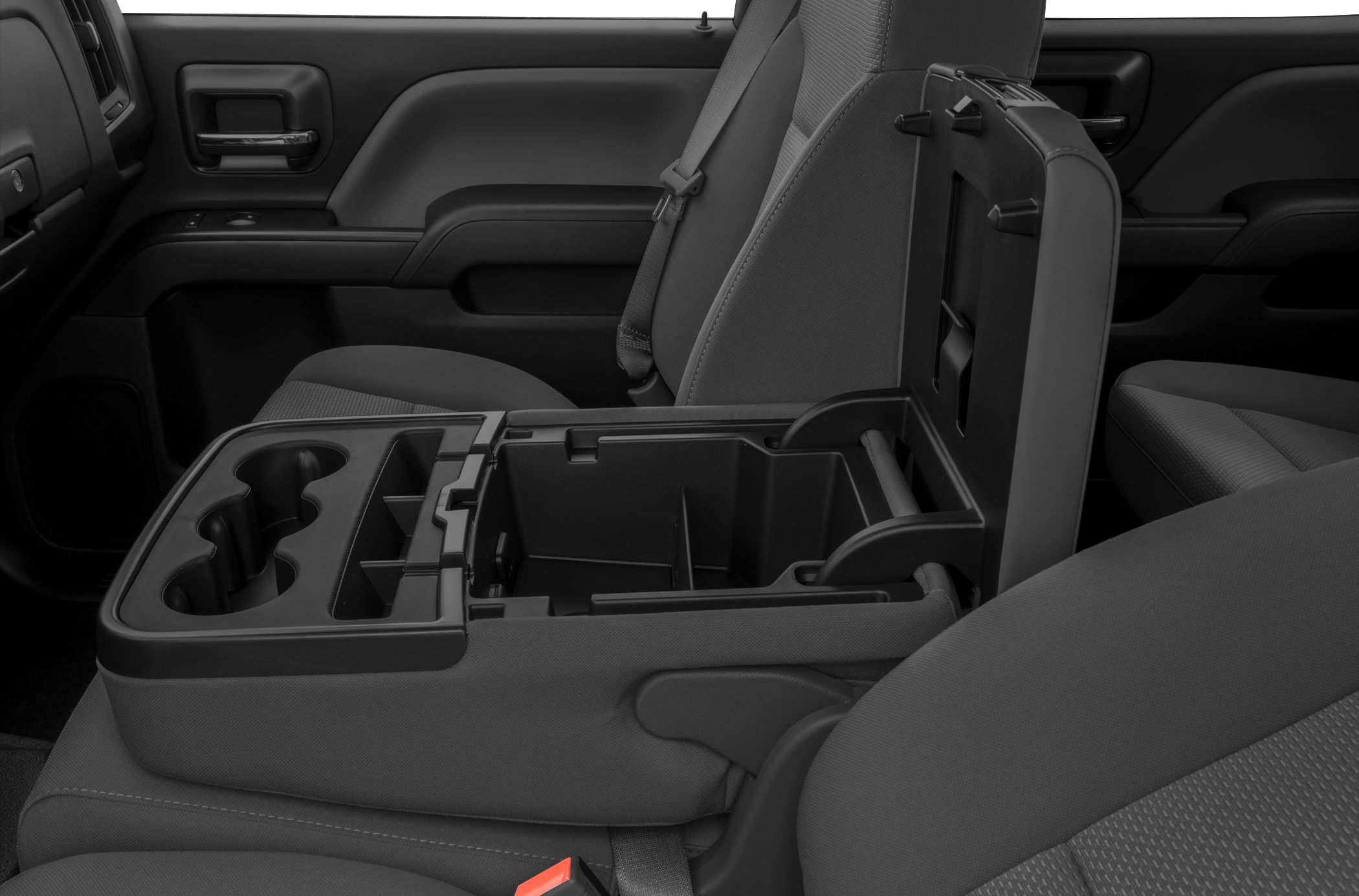 Open center console with cup holders and storage compartments in vehicle interior.
