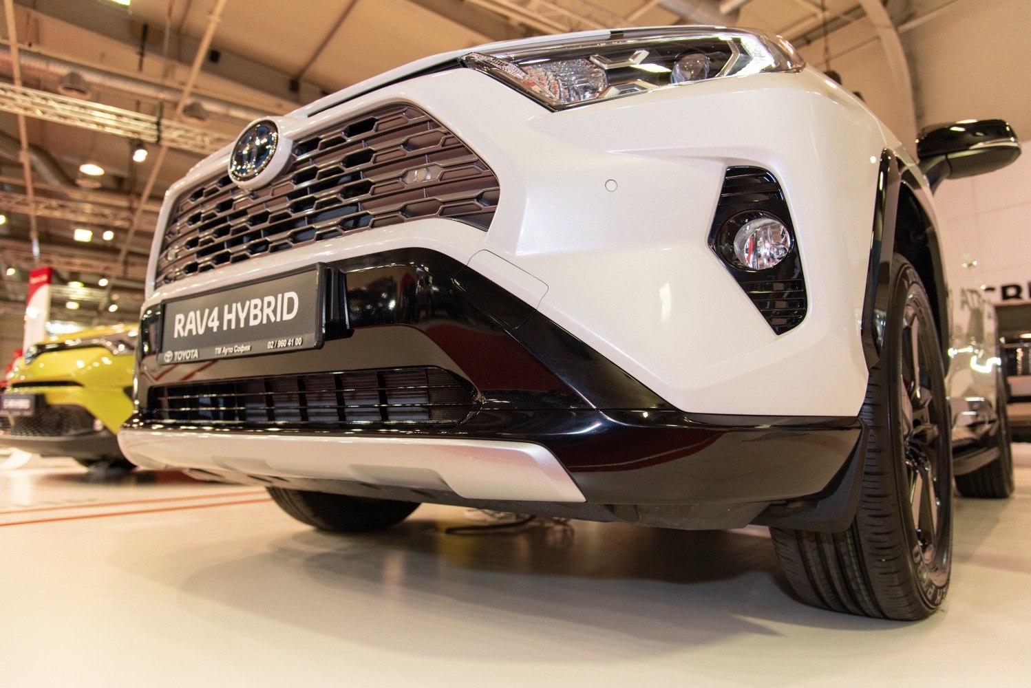 Close-up of hybrid SUV front grille, LED headlights, and fog lights