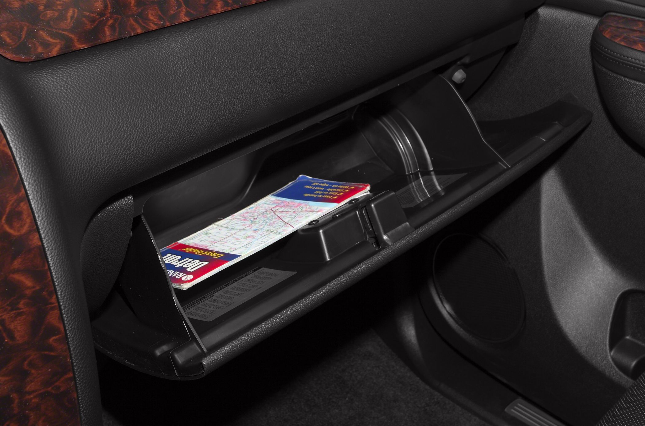 Open glovebox with a map inside in a vehicle interior