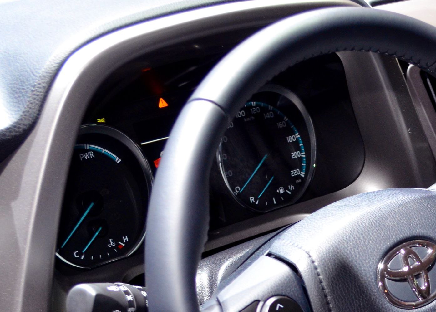 Instrument cluster and steering wheel close-up with speedometer and power gauge