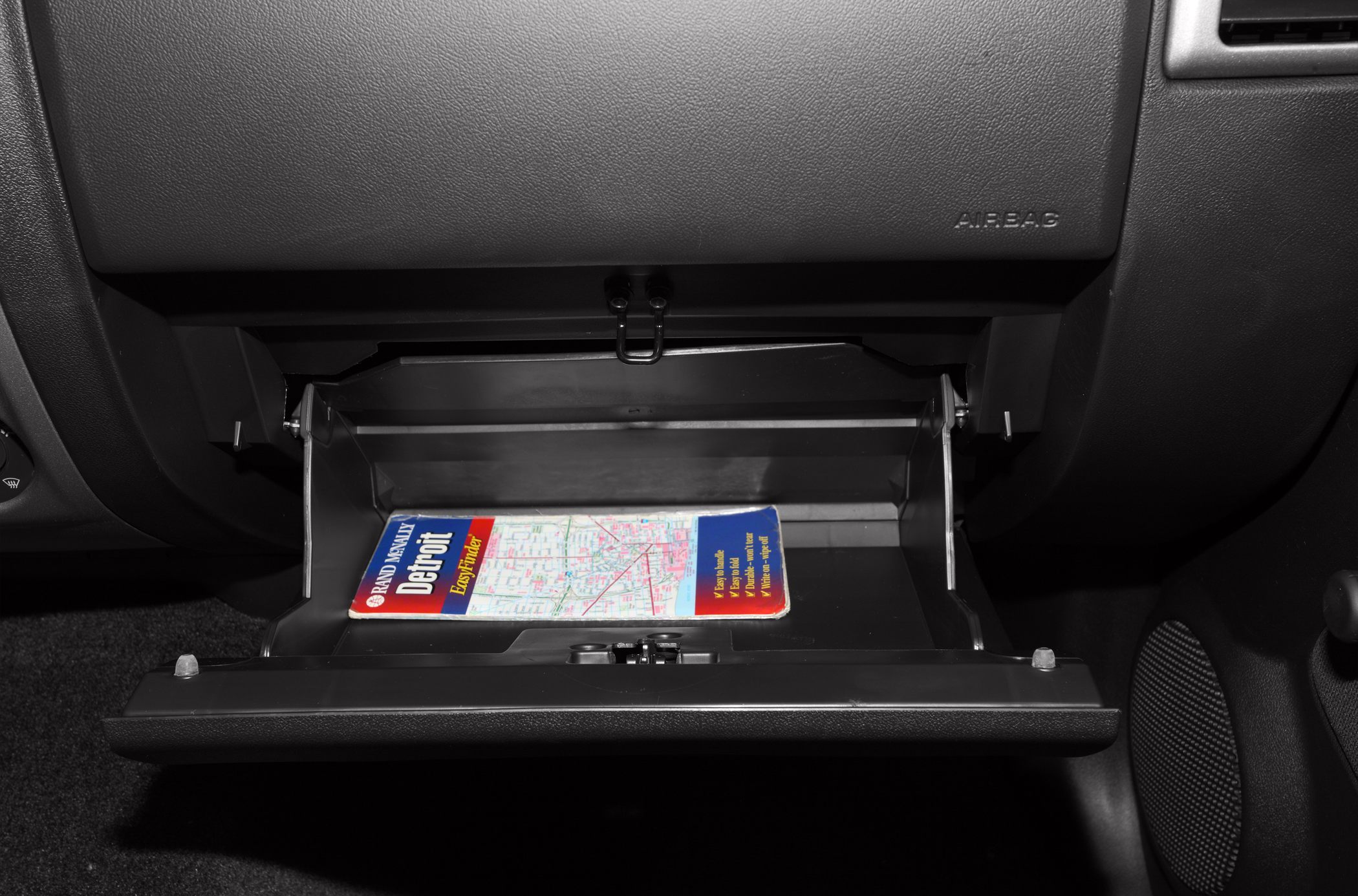Open glove compartment with a folded map inside