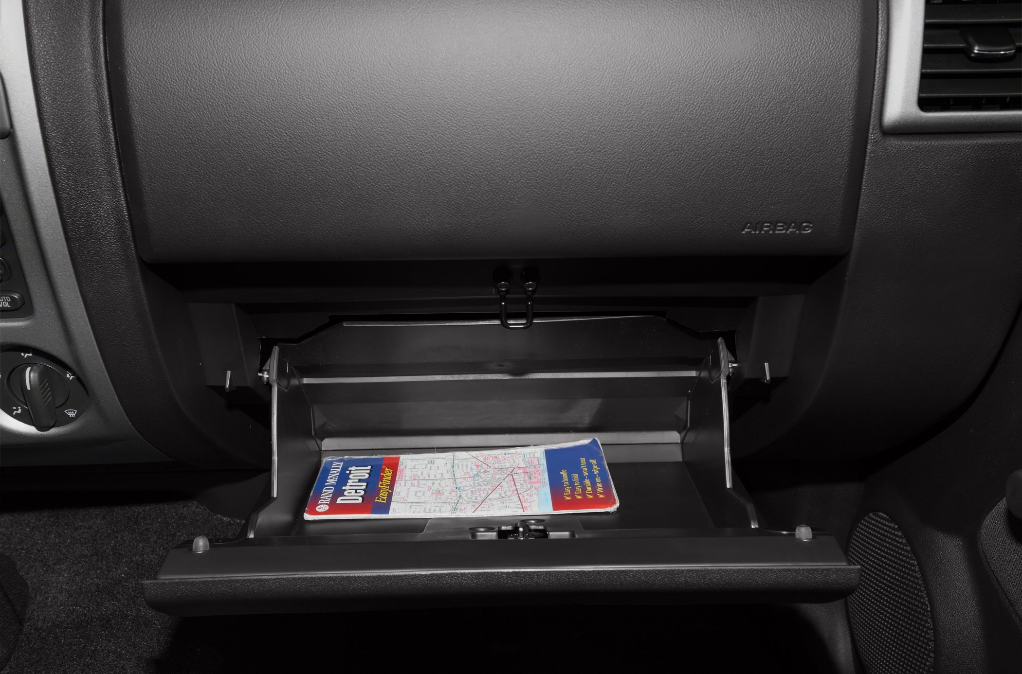 Open glove compartment with a map inside in vehicle interior