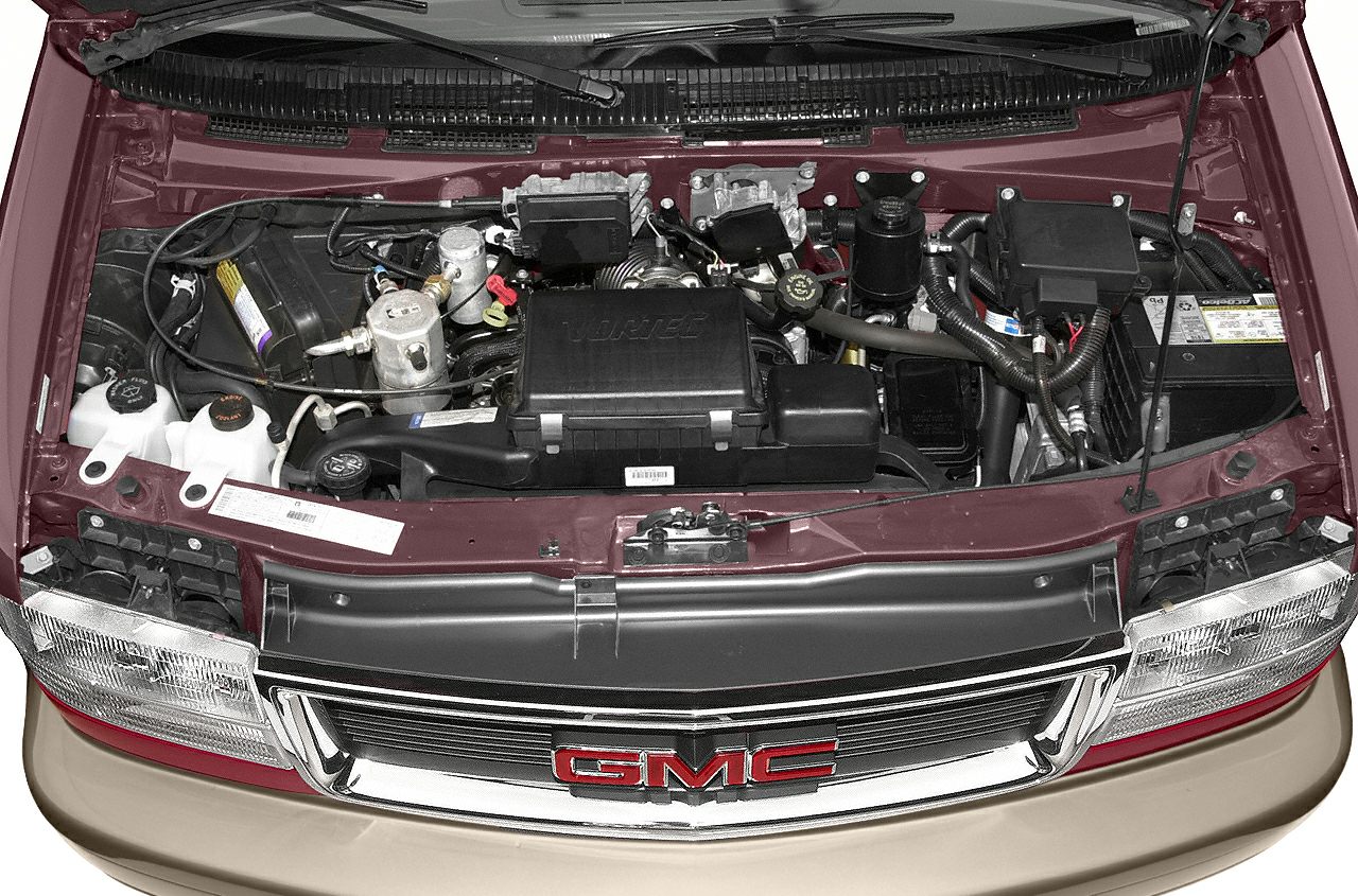 Front view of engine bay and open hood with visible vehicle grille and emblem