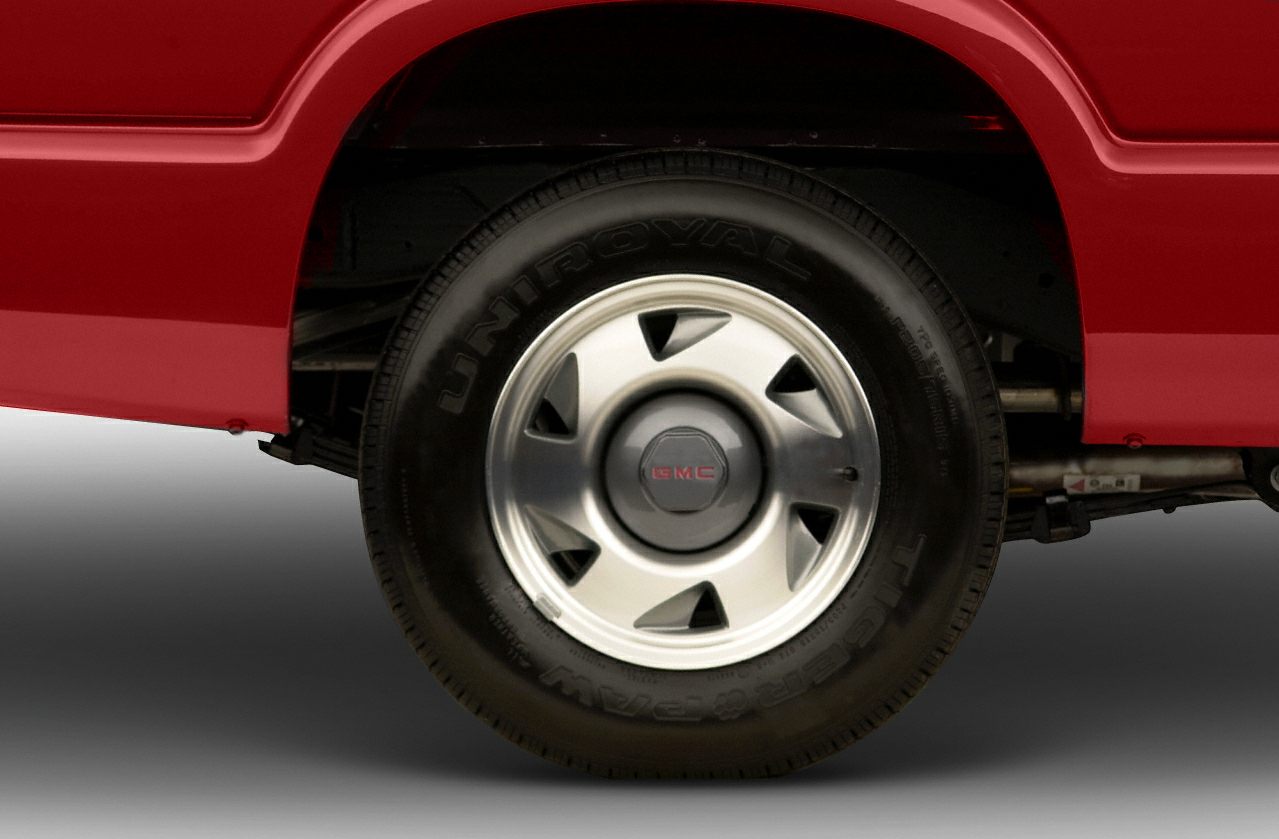 Close-up of wheel with Uniroyal tire and GMC rim on red vehicle body