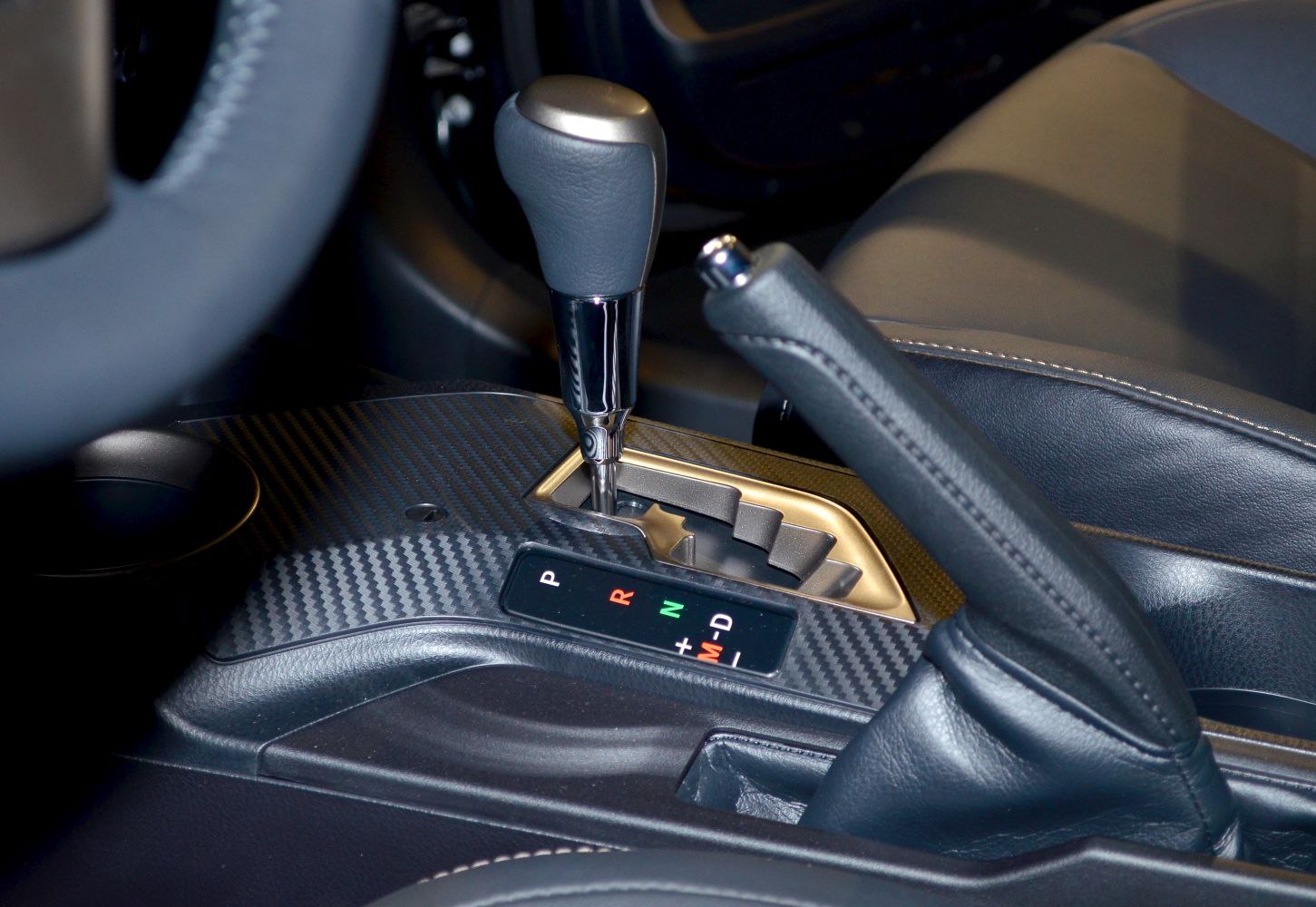 Close-up of gear shift and handbrake on carbon fiber trim
