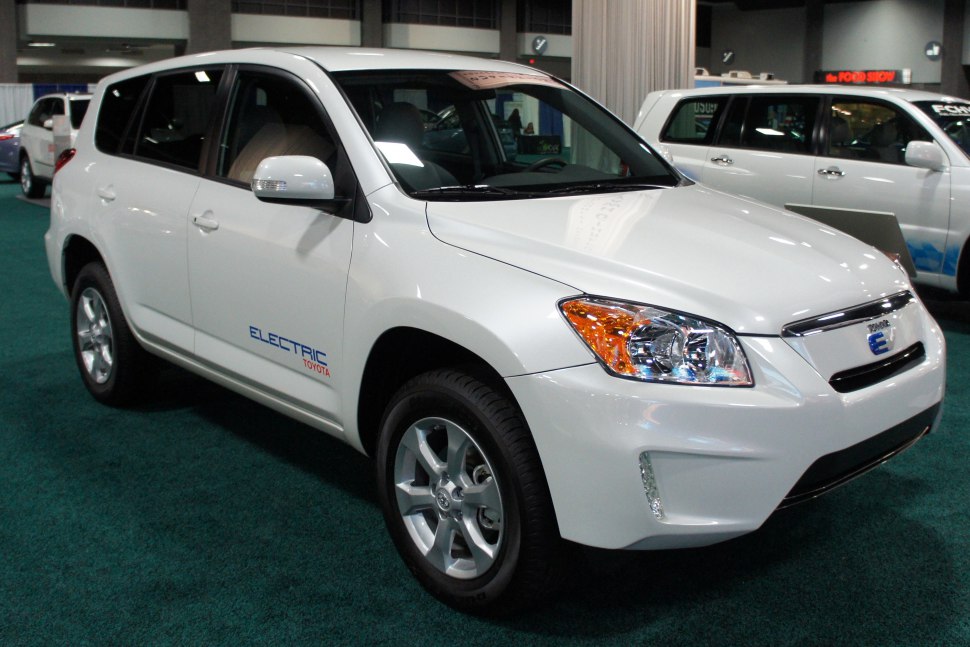 Front side view of a white electric SUV with prominent headlights and alloy wheels.