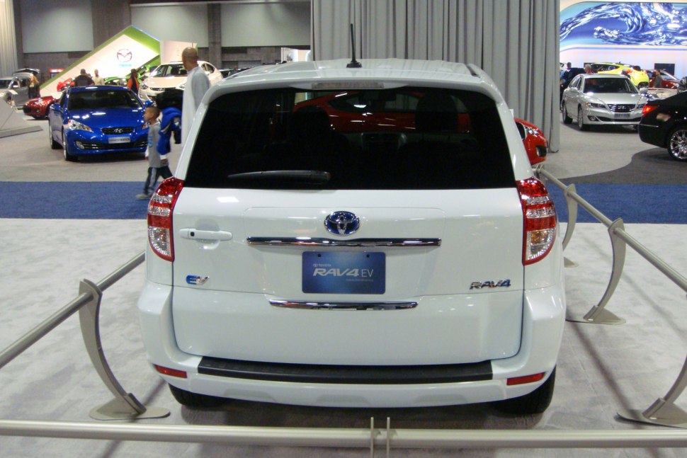 Rear view of white electric SUV with EV badge and distinct taillights.