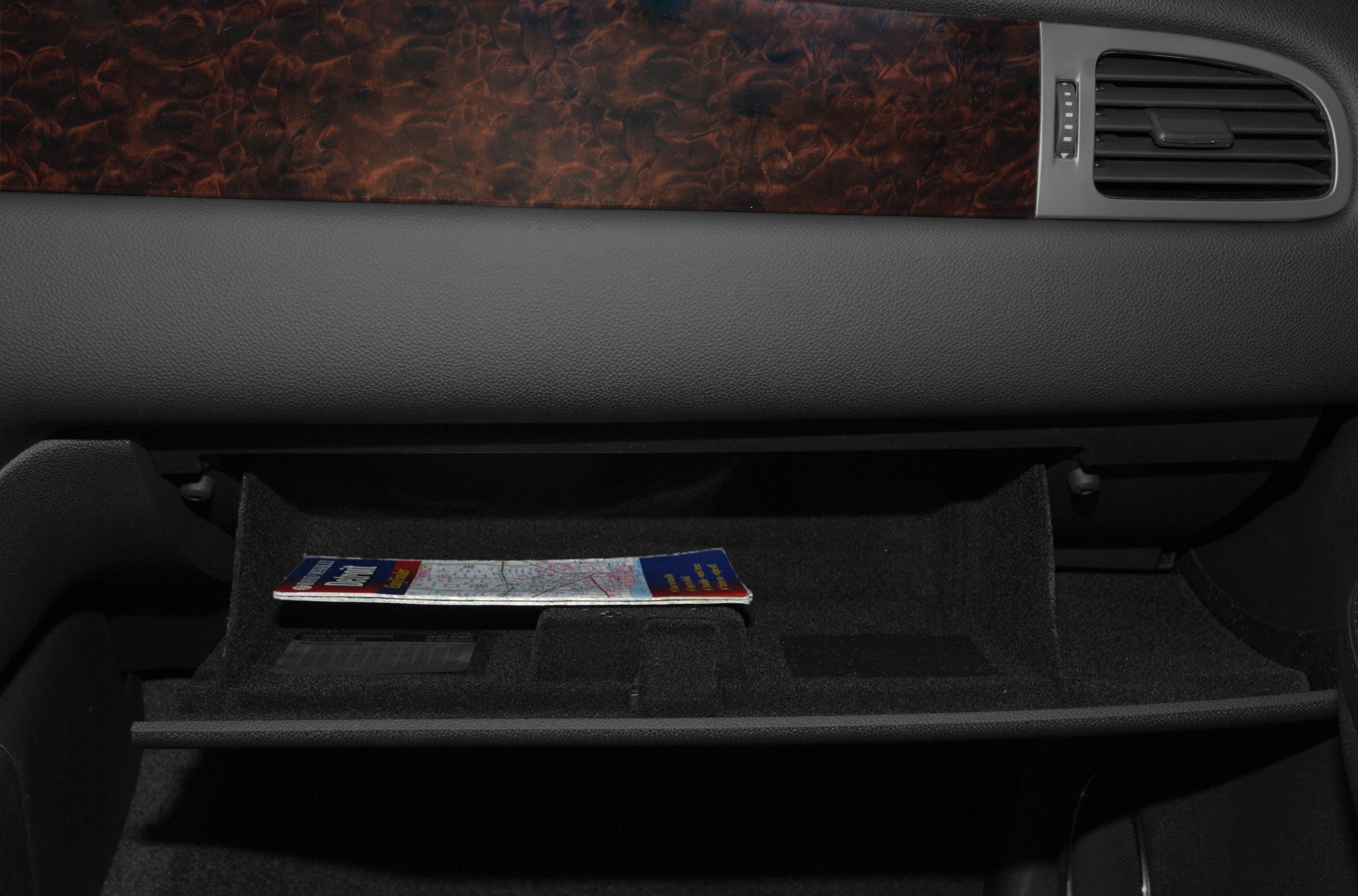 SUV interior glove compartment with wood trim and air vent