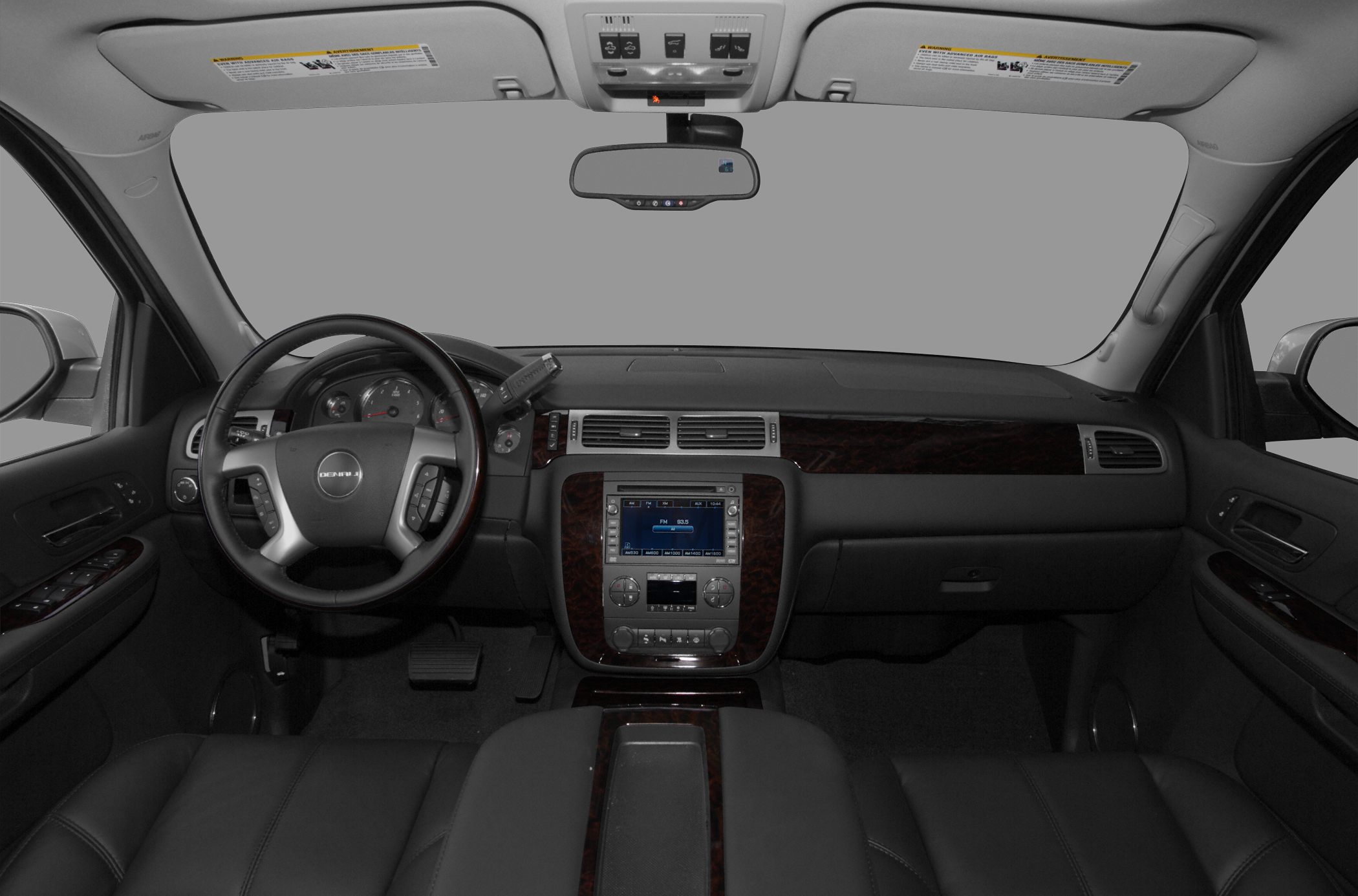 SUV interior with dashboard, steering wheel, and center console with wood trim