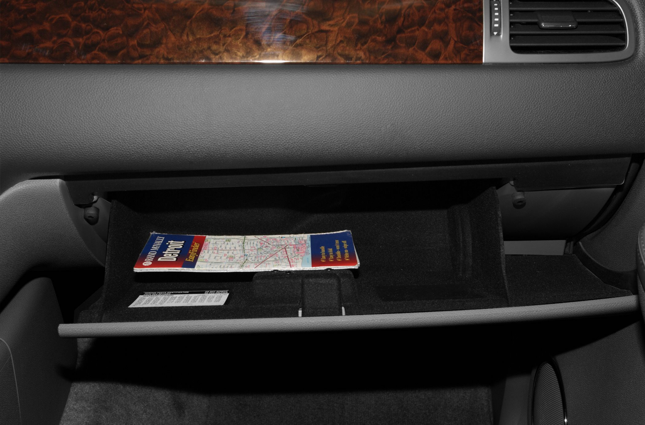 Open vehicle glove box with wood trim dashboard