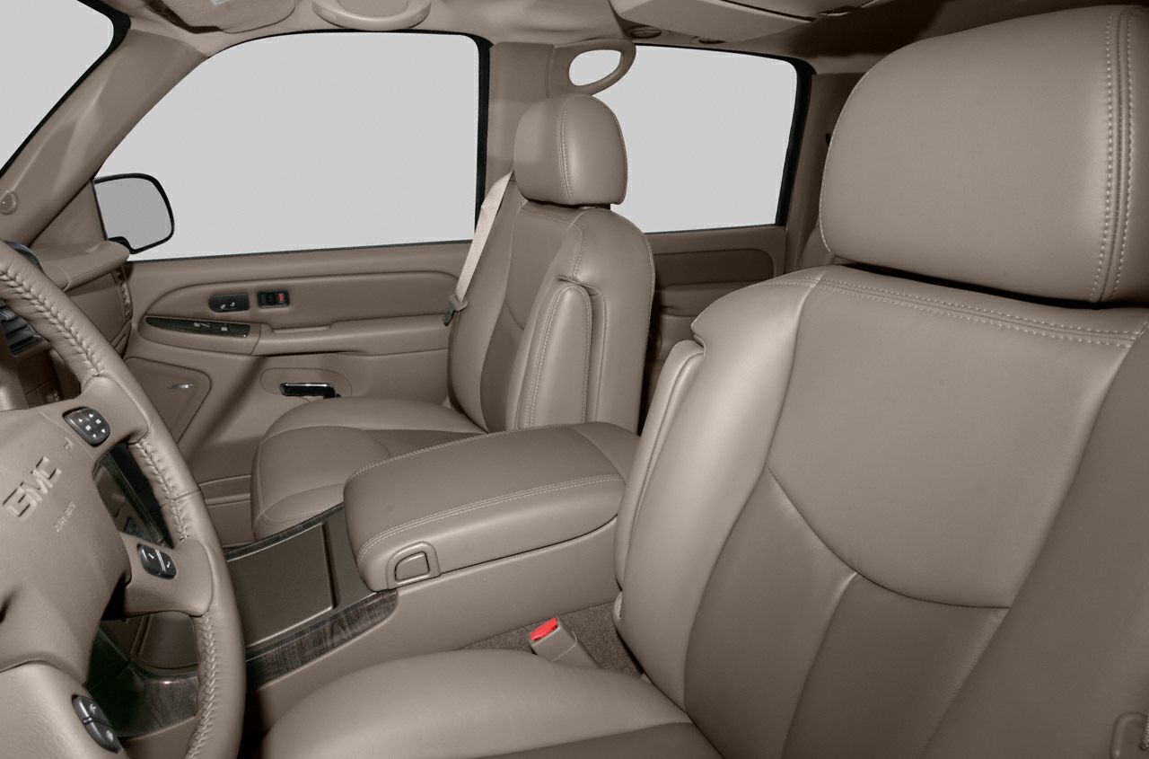 Beige leather front seats with center armrest and detailed door panel.