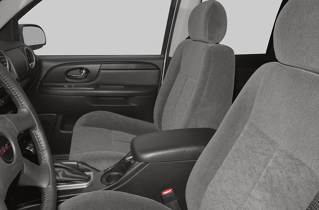 Front interior seats and dashboard with fabric upholstery and armrest