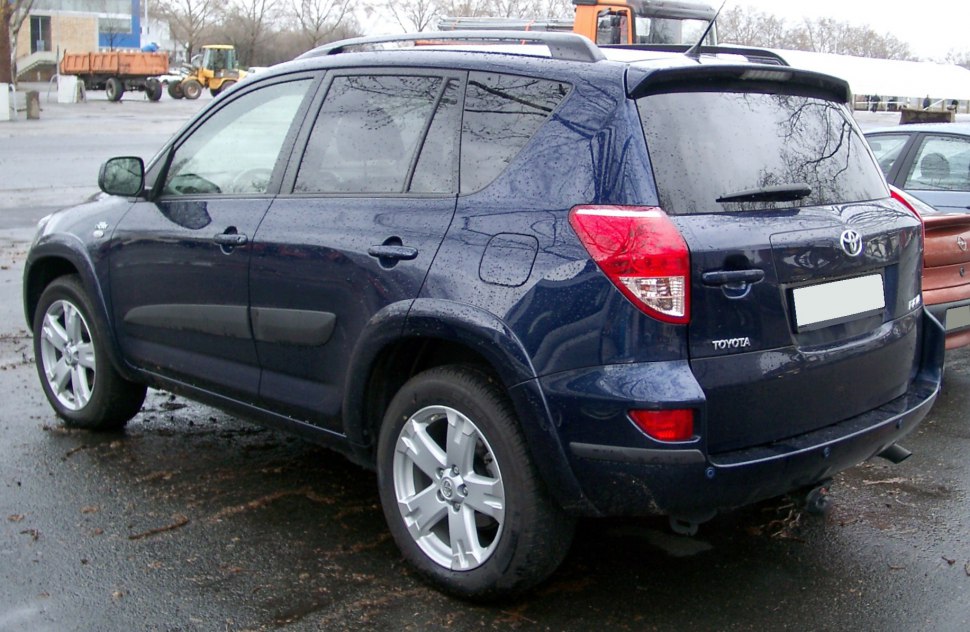 Rear side view of a dark blue SUV with alloy wheels and tinted windows.