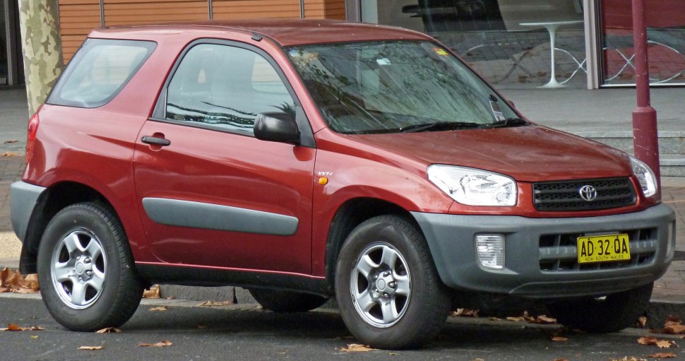 Red compact SUV with 3 doors, black plastic bumper, and alloy wheels