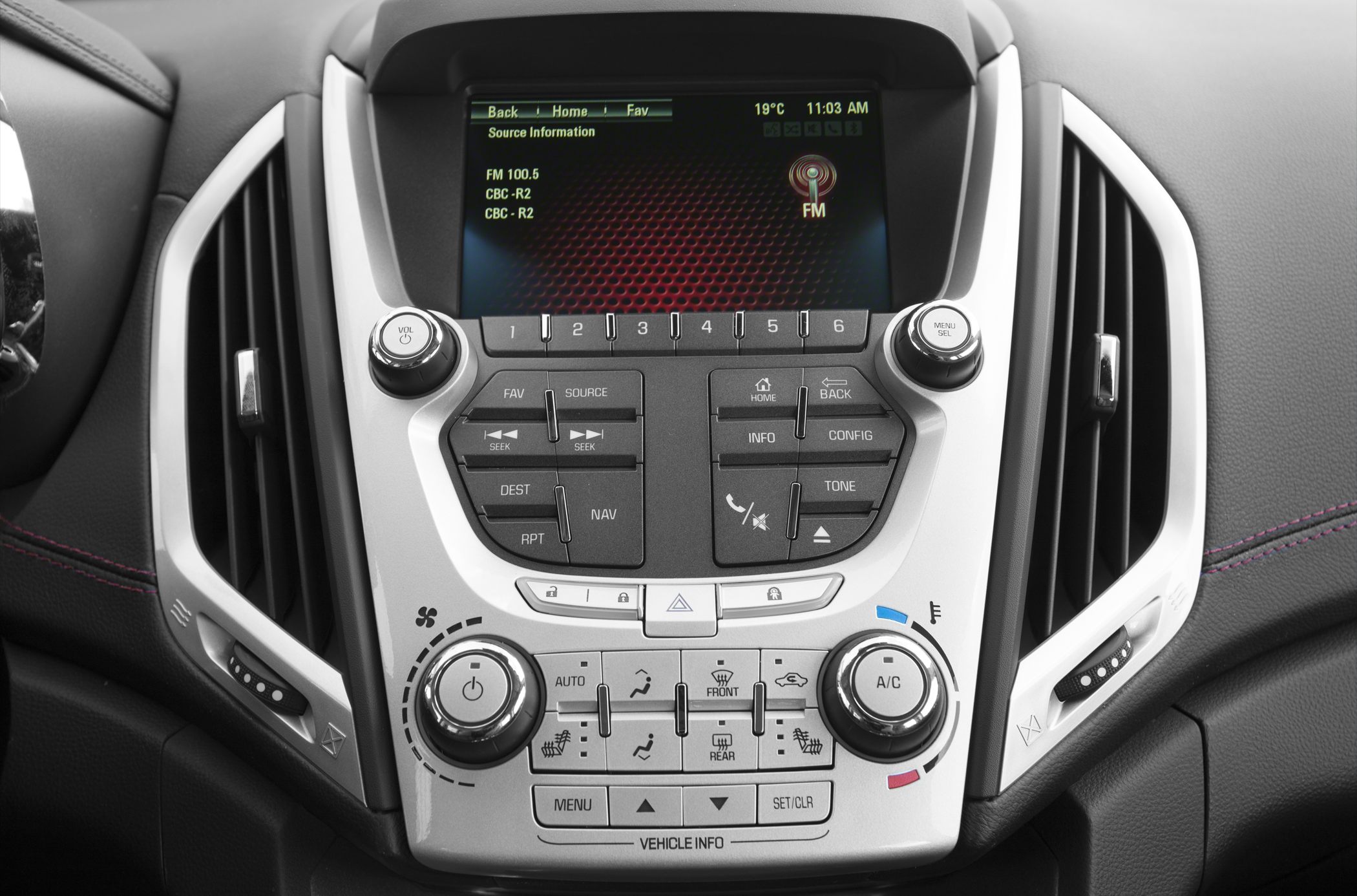 Infotainment screen with audio, navigation, and climate control knobs.