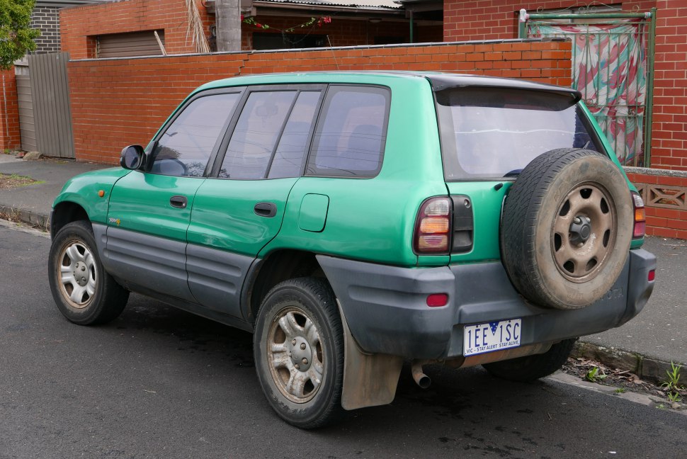 Rear side view of green 5-door SUV with spare tire on tailgate