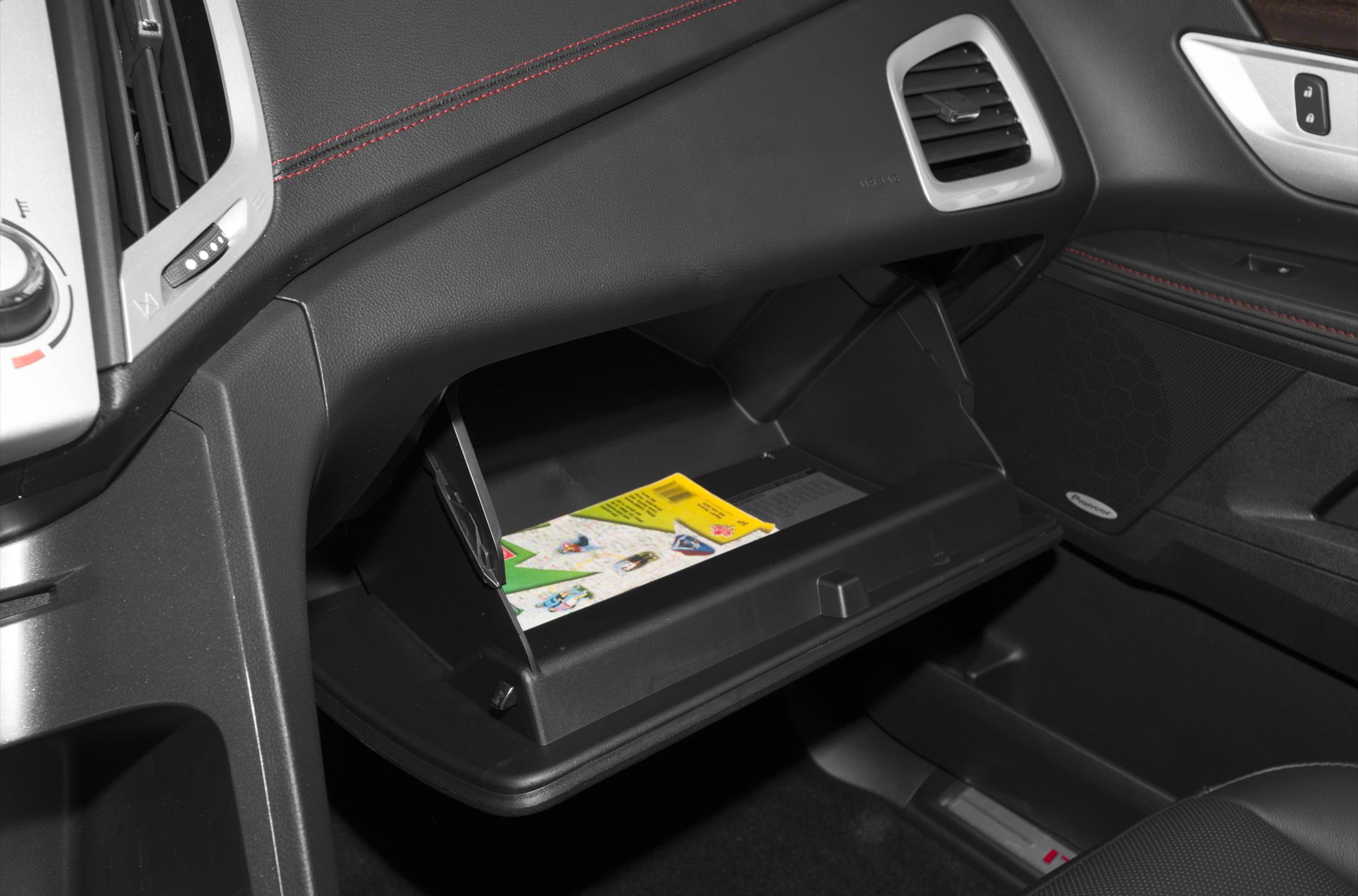 Open glove compartment with map inside a vehicle interior