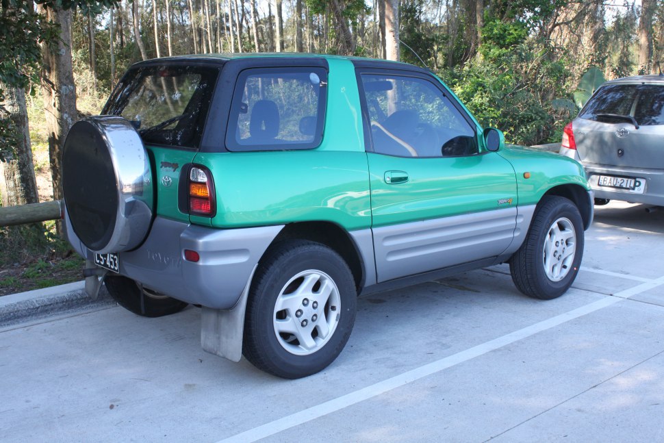 Rear side view of 3-door SUV with spare tire and two-tone body