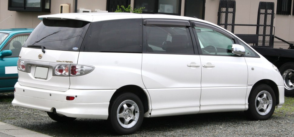 Rear side view of white minivan with tinted windows and alloy wheels