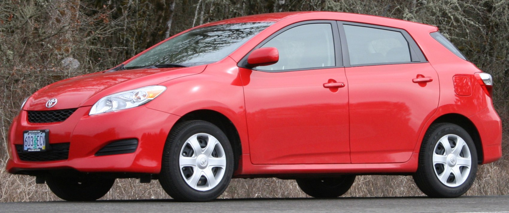 Red compact hatchback, rounded headlights, alloy wheels