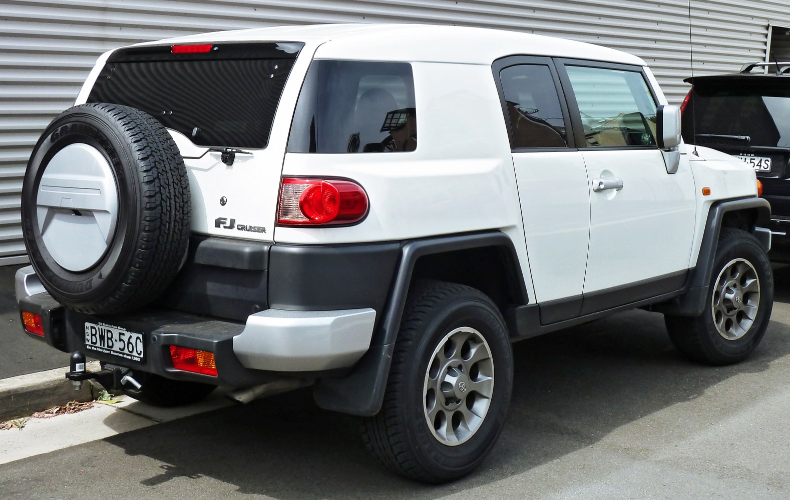 Rugged off-road SUV rear and side view with spare tire mounted on tailgate.