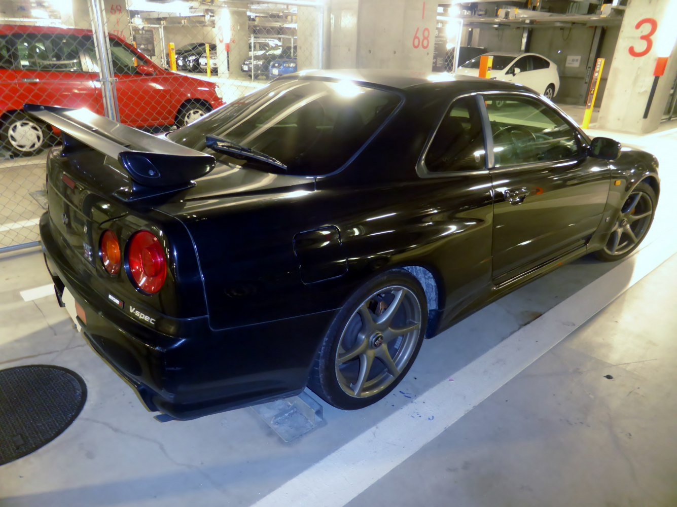 Black sports coupe with rear spoiler and alloy wheels