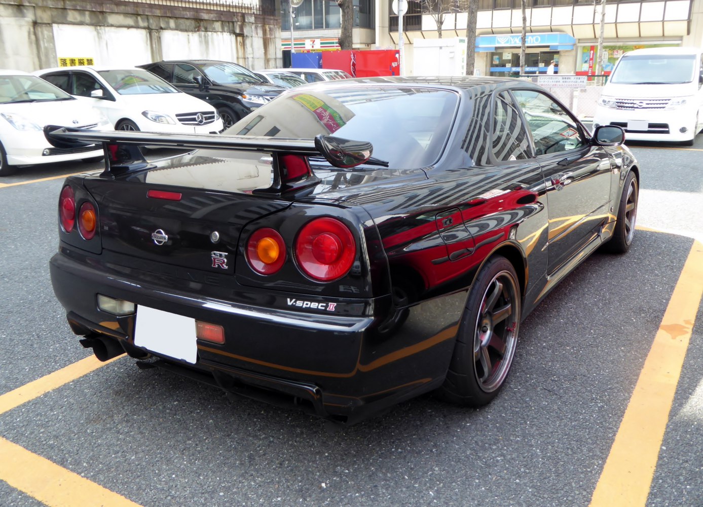 Rear view of black sports coupe with large spoiler and round taillights