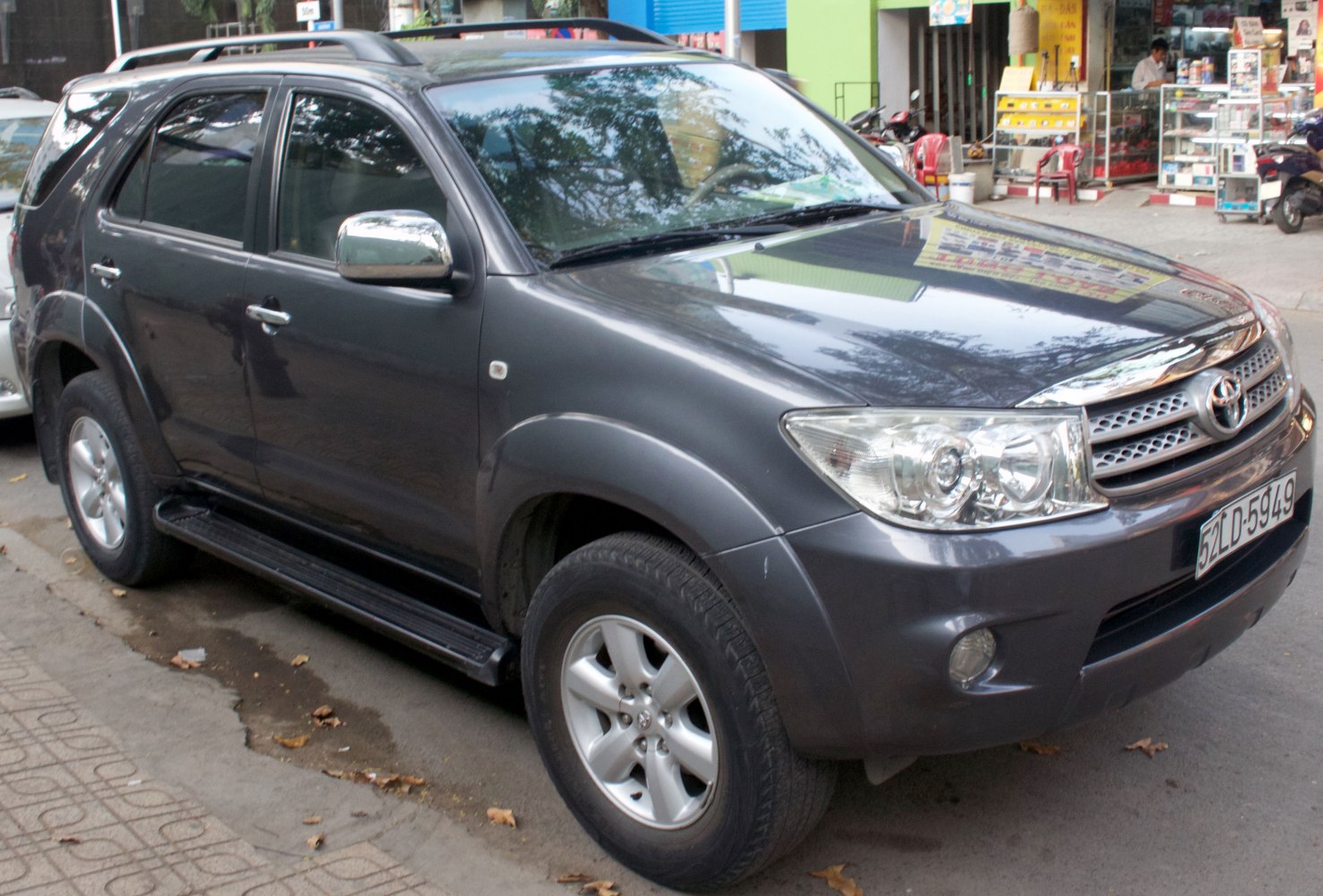 Front-side view of SUV featuring headlights, alloy wheels, and running boards