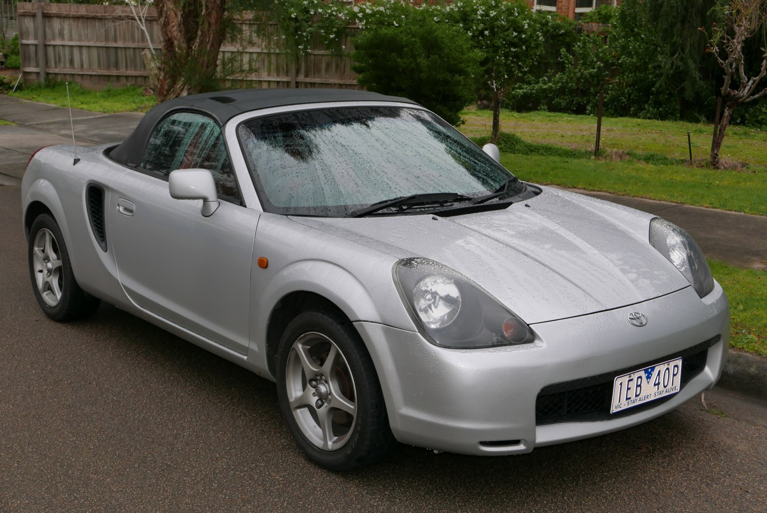 Silver convertible roadster with rounded headlights and side air intakes